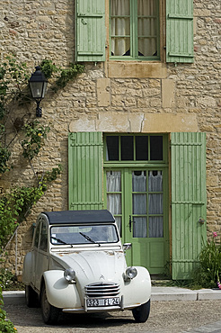 An old Deux Chevaux car parked in front of an old village house, Dordogne, France, Europe