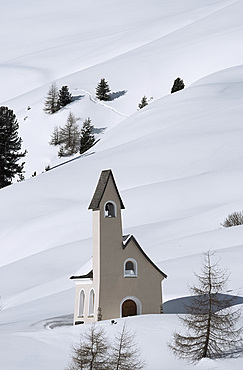 A modern style chapel on a snow covered hillside at Passo Sella in the Dolomites, South Tyrol, Italy, Europe