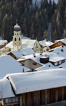 An early morning view of snow covered rooftops in San Cassiano near the Alta Badia ski area, Dolomites, South Tyrol, Italy, Europe