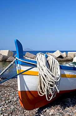 A colourful wooden fishing boat on the rocky beach at Lingua, Salina, The Aeolian Islands, off Sicily, Messina Province, Italy, Mediterranean, Europe