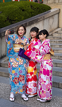 Young Japanese women dressed in colourful kimonos taking selfies in Kyoto, Japan, Asia