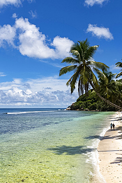 A couple walking along Anse Parnel on the southeast coast of Mahe, Seychelles, Indian Ocean, Africa