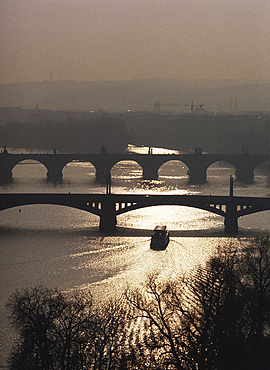 A boat passes under one of the bridges over the Vltava River in Prague, Czech Republic, Europe