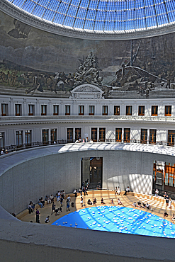 Fondation Pinault in La Bourse de Commerce, Paris. The circular central structure and pool designed by Tadao Ando set within the Bourse originally used to trade wheat and other commodities below the glass dome ceiling and mural of the four seasons.