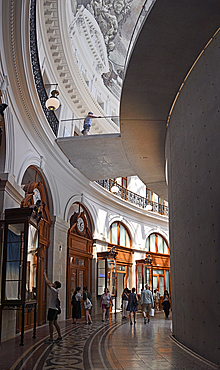 Fondation Pinault in La Bourse de Commerce, Paris. The circular central structure and pool designed by Tadao Ando set within the Bourse originally used to trade wheat and other commodities below the glass dome ceiling and mural of the four seasons.