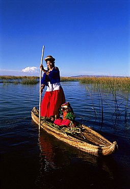 Uros Indian woman and traditional reed boat, Islas Flotantes, Lake Titicaca, Peru, South America