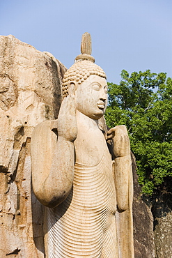 Giant standing statue of the Buddha, his right hand raised in blessing, the left hand lifting the robe symbolising reincarnation, Aukana, Sri Lanka, Asia