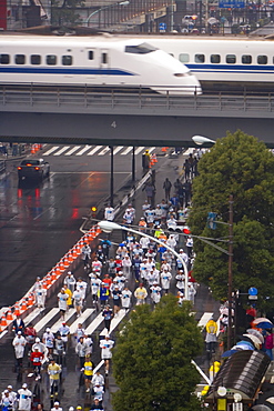 Elevated view of runners competing in the 2007 Tokyo marathon, Shinkansen (Bullet train) passing overhead, Sukiyabashi crossing, Ginza, Tokyo, Honshu, Japan, Asia