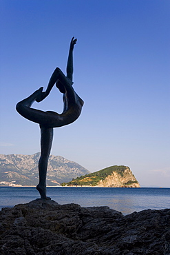 Statue sillhouetted against St. Nikola Island, Budva, Montenegro, Balkans, Europe