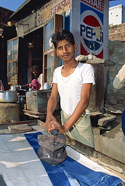 Man ironing pair of jeans, Fatehpur Sikri, Uttar Pradesh, India, Asia