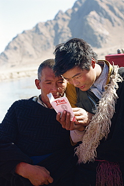 Two men studying a phrase book in Tibet, China, Asia