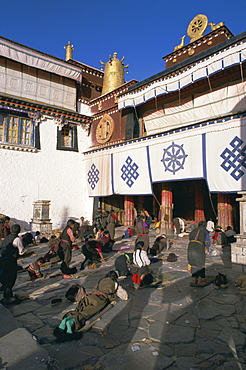 Tibetan Buddhist pilgrims prostrating in front of the Jokhang temple, Lhasa, Tibet, China, Asia