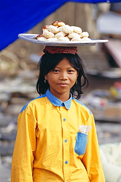 Portrait of a girl carrying buns, Phnom Penh, Cambodia, Indochina, Asia