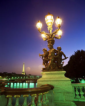 Eiffel Tower illuminated at dusk from Alexandre III Bridge, Paris, France, Europe