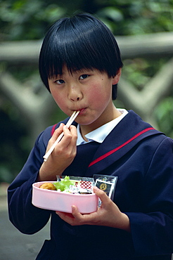 School girl eating her lunch with chop sticks, Japan, Asia