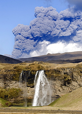 Distant view of the Seljalandsfoss waterfall with the ash plume of the Eyjafjallajokull eruption in the distance, near Hella, southern Iceland, Iceland, Polar Regions