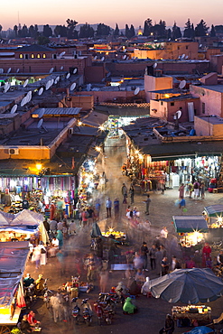 Crowds of locals and tourists walking among the shops and stalls in the Djemaa el Fna at sunset, Marrakech, Morocco, North Africa, Africa