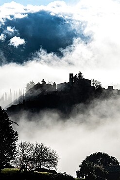 Silhouetted village of Montefioralle in early morning mist as sun breaks through, Tuscany, Italy, Europe