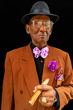 Man standing dressed as 1950s dandy/gangster with fedora hat and big cigar, Havana, Cuba (Model Release)