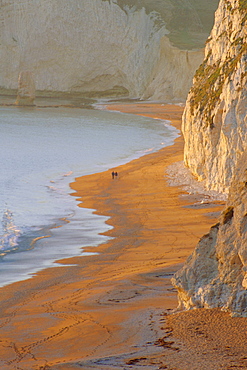 Couple walking on beach. Isle of Purbeck, Dorset, England UK 