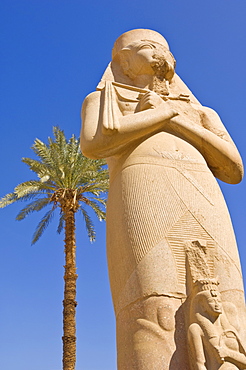 Statue of the great pharaoh Rameses II with small statue of his daughter Bent'anta between his legs in the forecourt behind the first Pylon of the great Temple at Karnak, near  Luxor, Thebes, UNESCO World Heritage Site, Egypt, North Africa, Africa