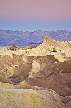 Manly Beacon and the Siltstone eroded foothills formations at Zabriske Poin at sunrise, Furnace creek, Death Valley National Park, California, United States of America, North America