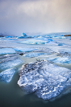 Frozen icebergs locked in the frozen waters of Fjallsarlon Glacier lagoon, South East Iceland, Iceland, Polar Regions