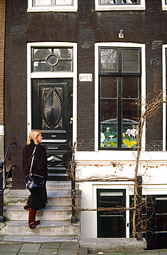 Netherlands, Amsterdam, Woman Entering House On A Canal