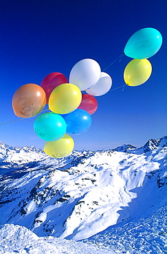 France, Alps In Winter, Colored Balloons Against Mountain Landscape 