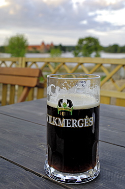 Vilkmerges, Lithuanian dark beer, with Trakai Castle in the background, Lithuania, Baltic States, Europe