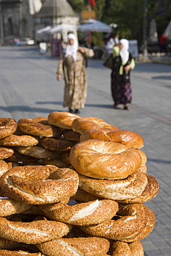 Traditional Turkish bagels with sesame seeds for sale, ladies in traditional costume in distance, Istanbul, Turkey, Europe