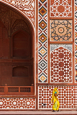 Indian lady in traditional dress walking past Akbar's Mausoleum in Sikandra, Uttar Pradesh, India, Asia