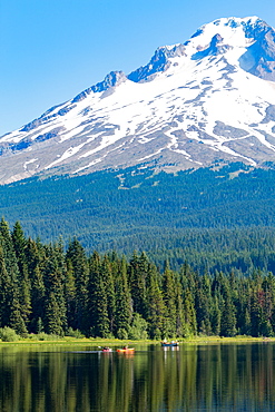 Canoes and rowboat on the still waters of Trillium Lake with Mount Hood, part of the Cascade Range, Oregon, United States of America, North America