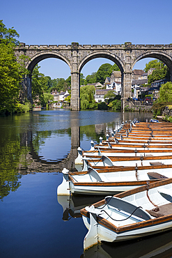 Row boats for hire in front of the Railway Viaduct over the river Nidd in Knaresborogh In the county of Yorkshire.