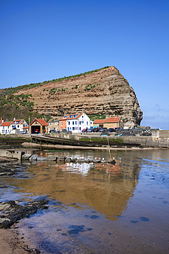 Houses nestled under the high cliffs in the small fishing village of Staithes on the Yorkshire coast.
