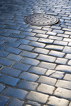 Cobbled street, manhole cover in Old Town, Prague, Czech Republic, Europe