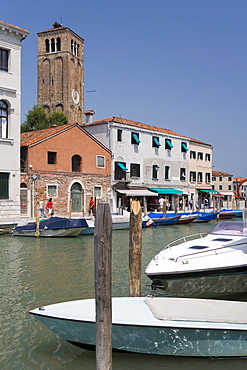 Boats in canal with Campanile of Santi Maria e Donato on island of Murano, Venice, Italy