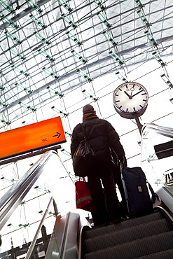 Passenger on escalator and platform clock at modern train station, Berlin, Germany, europe