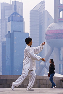 Morning exercises along the Huangpu river in Huangpu Park on the Bund with a backdrop of Pudong's modern high rise skyline, Shanghai, China, Asia