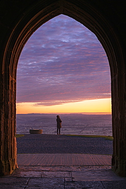 Woman watching sun rising from Glastonbury Tor, Somerset, England, United Kingdom, Europe