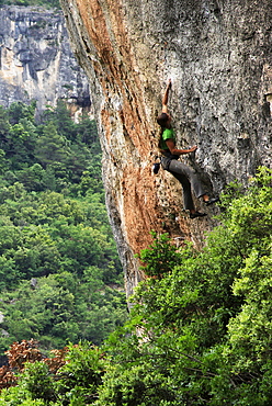 A woman tackles a very difficult climb on limestone cliffs near Siuarana, a medieval village near Reus and Barcelona, Catalonia, Spain, Europe