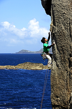 A climber scales cliffs at Sennen Cove, Cornwall, England, United Kingdom, Europe