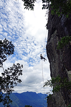 A rock climber abseils from the famous granite cliffs of Marumbi, a mountain in Parana State, south Brazil, South America