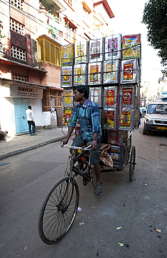 Piled up empty oil tins, being carried by cycle rickshaw to be recycled and used for slum house walls, Kolkata (Calcutta), West Bengal, India, Asia