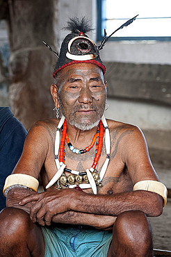 Naga head hunter, Wokshing Pensha, wearing Naga tribal necklaces and hat, and chest tattoo marking him as having taken a head, Nagaland, India, Asia