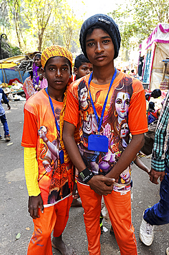 Two young pilgrims, in orange T shirts with images of Lord Shiva, going to Gupteswar cave Shiva shrine, Jeypore, Odisha, India, Asia