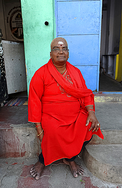 Woman with shaved head, Shiva devotee, dressed in red, outside 11th century Brihadisvara Cholan temple, Thanjavur, Tamil Nadu, India, Asia