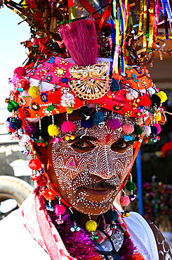 Adivasi tribal man, face decorated and wearing ornate decorated headgear to celebrate Holi festival, Kavant, Gujarat, India, Asia