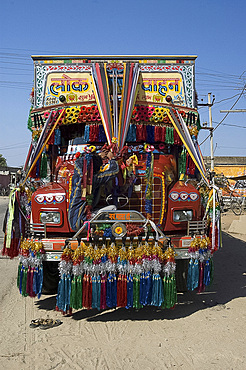 Man fixing decoration onto truck for Diwali celebrations, Pali district, Rajasthan, India, Asia