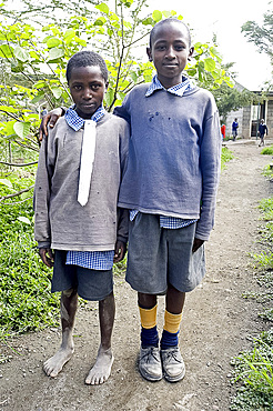 Two schoolboys in make-do school uniform, one barefoot, with white cotton fabric pinned in place of school tie, Langalanga Primary School, Gilgil district, Rift Valley, Kenya, East Africa, Africa